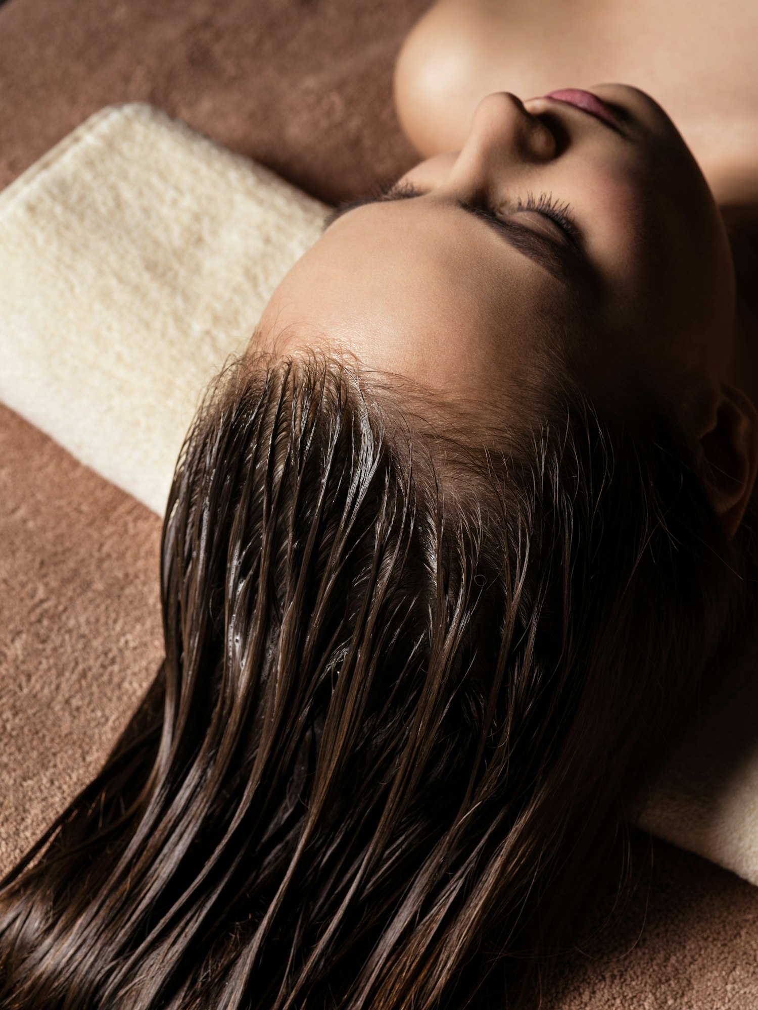 Woman receiving hair care procedure in spa salon